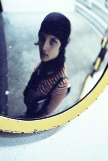 young woman staring into a convex mirror